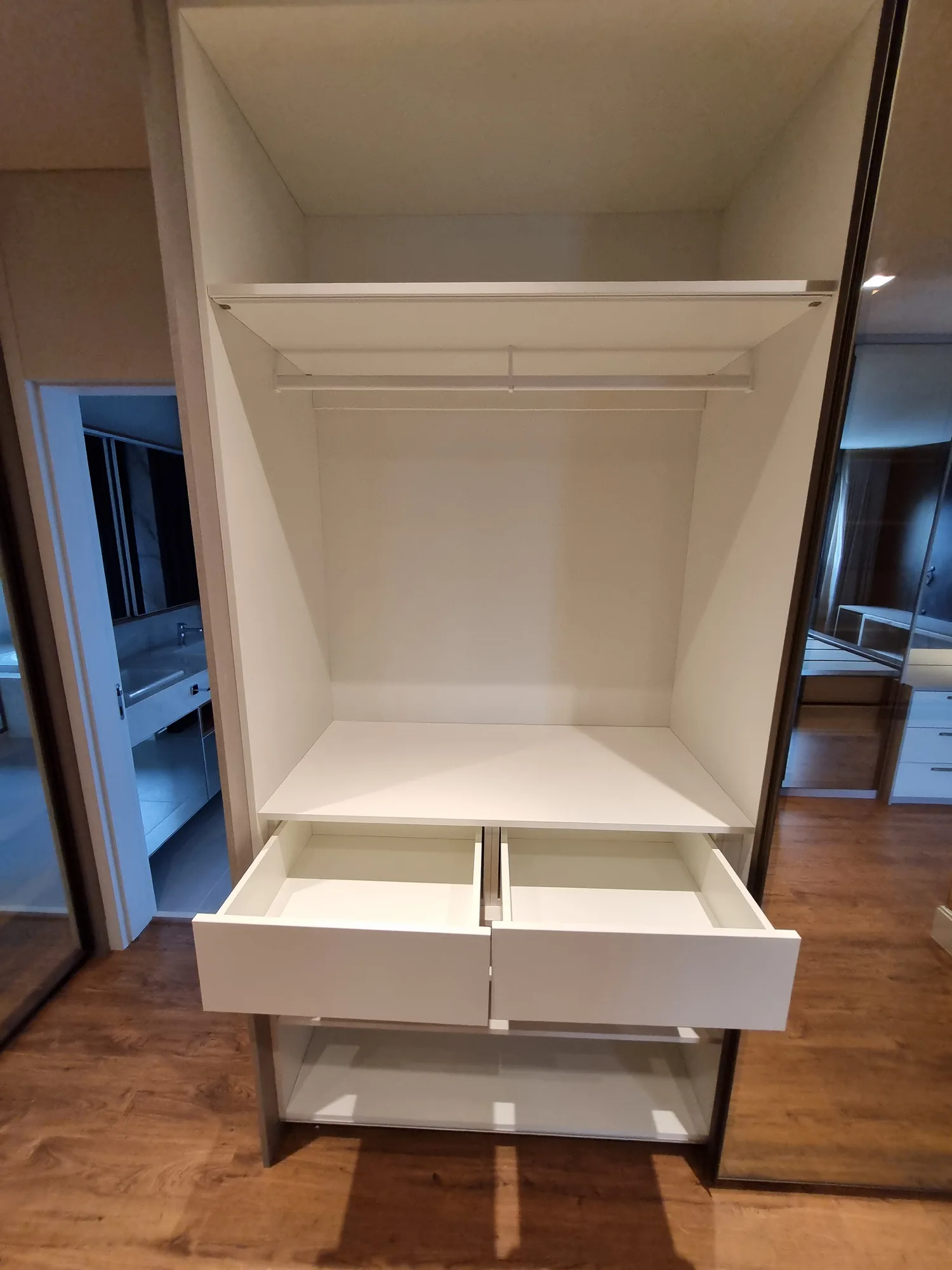 Closet vazio de um apartamento recém-entregue, com gavetas abertas antes da chegada do acervo